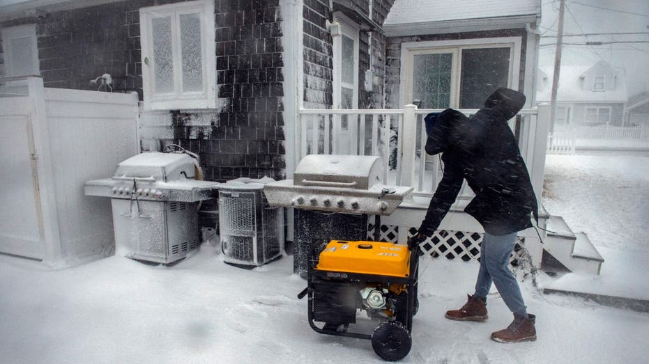 man starting a generator in the snow