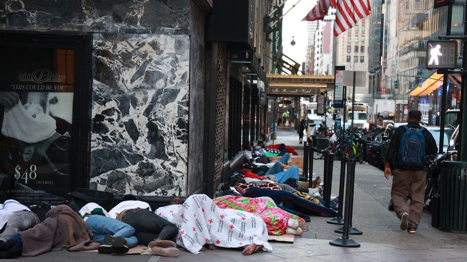 Migrants sleep on street outside Roosevelt Hotel