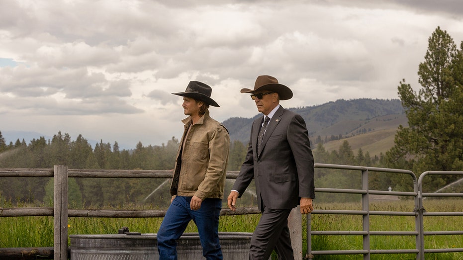 Kevin Costner walking with co-star in a beautiful landscape