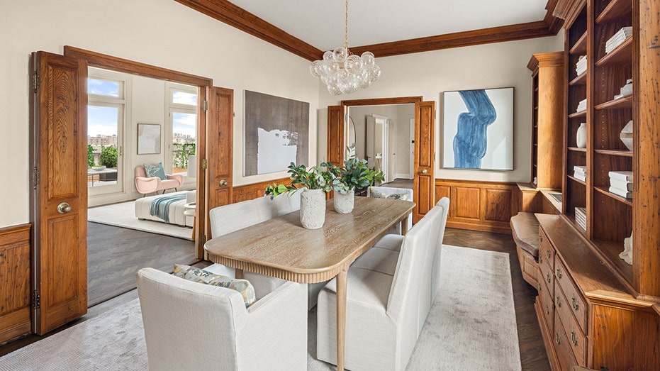 The dining room features dark hardwood flooring, mixed texture walls, and built-in cabinetry.