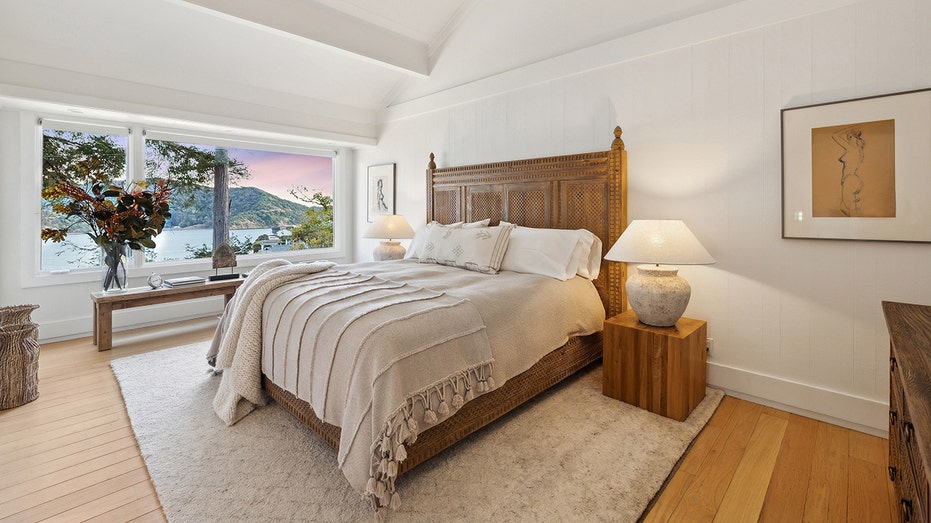 Wooden bed with a sunset shown through the window