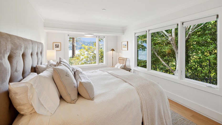 A white/black bedroom with two large windows overlooking Tiburon