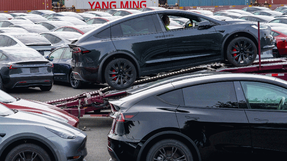 A worker positions a new Tesla Model X on a truck at a logistics drop zone in Seattle, Washington, US, on Thursday, Aug. 22, 2024. The world's largest seller of battery-electric vehicles is well off its pace of 1.8 million deliveries last year and reiterated that volume growth will be notably lower in 2024. Photographer: M. Scott Brauer/Bloomberg via Getty Images