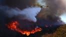 A firefighting plane makes a drop on the Palisades Fire in Pacific Palisades on Jan. 7. The Palisades fire is being pushed by gusting Santa Ana winds that were expected to continue for two more days.