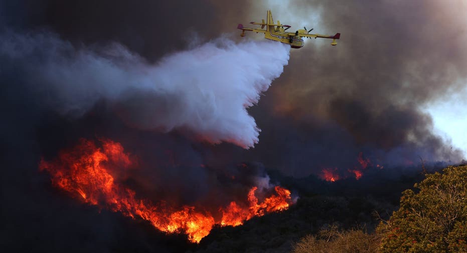 PACIFIC PALISADES, CALIF JANUARY 7, 2024 A firefighting plane makes a drop on the Palisades fire in Pacific Palisades on Tuesday, Jan. 7. The Palisades fire is being pushed by gusting Santa Ana winds that were expected to continue for two more days. (Brian van der Brug / Los Angeles Times via Getty Images)
