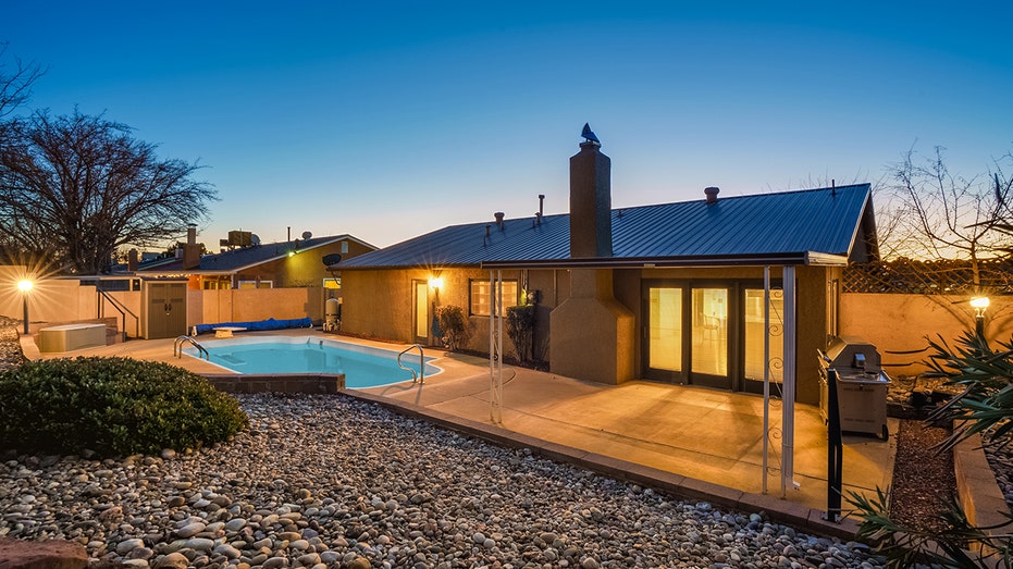 The backyard has a swimming pool with a diving board.