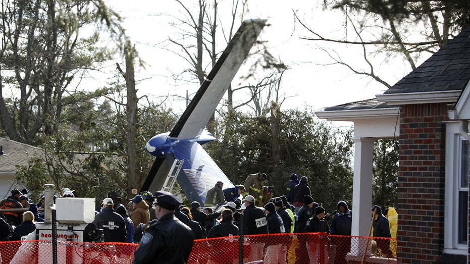 Workers clear debris from a Buffalo plane crash