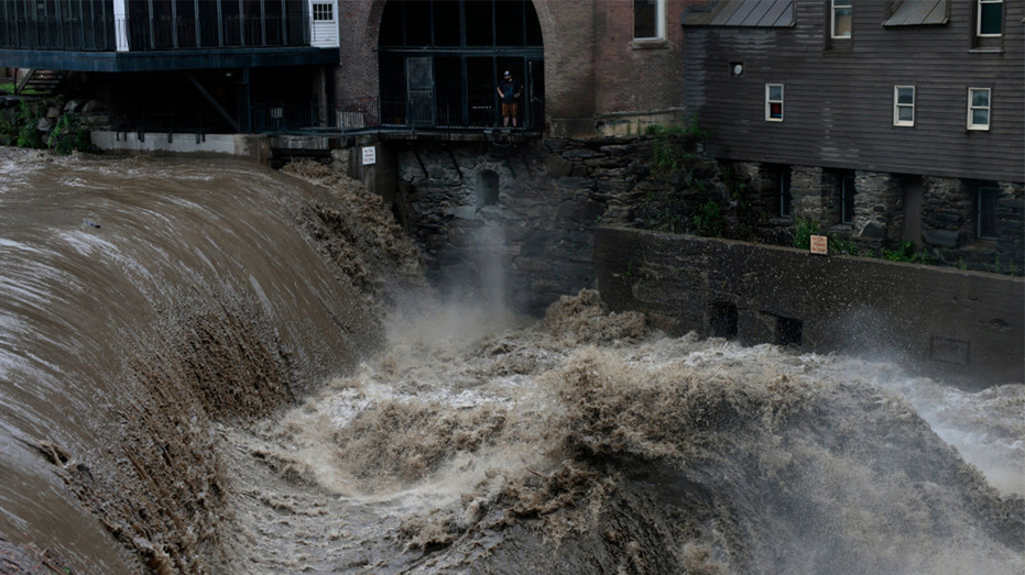 Seorang pria menyaksikan banjir di Vermont