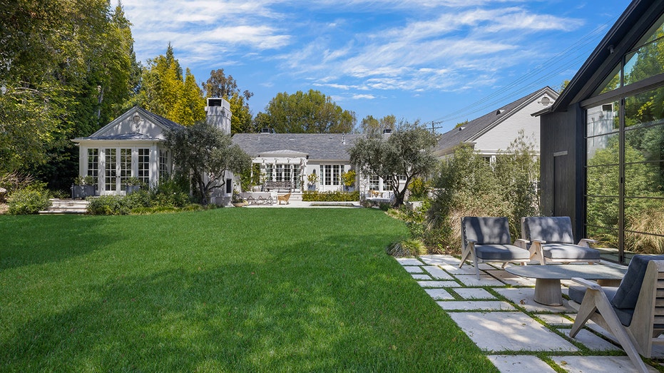 In addition to the guest house, the backyard features a large grass patch and a dipping pool.