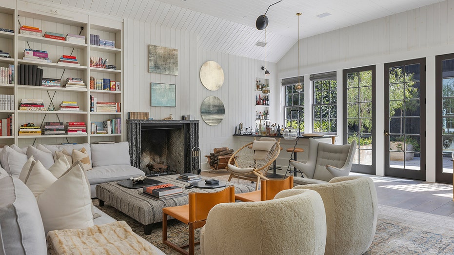 The family room has built -in bookshelves and windows from floor to ceiling.