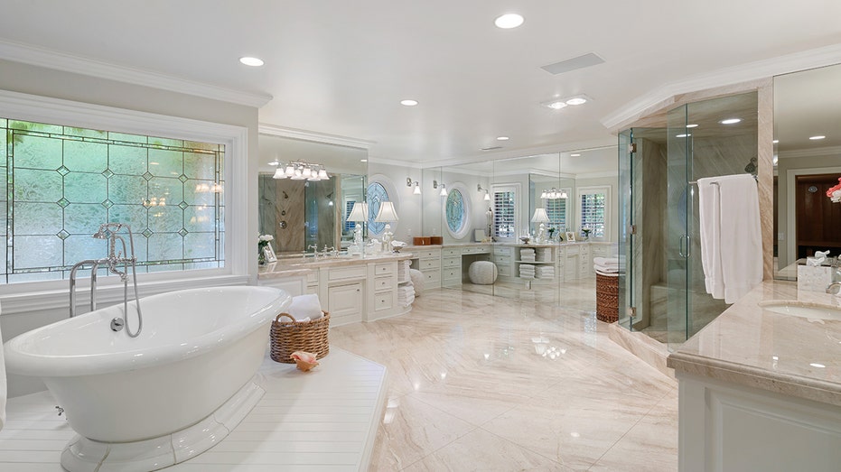 The ensuite bathroom features multiple vanities, a soaking tub and a standing shower.