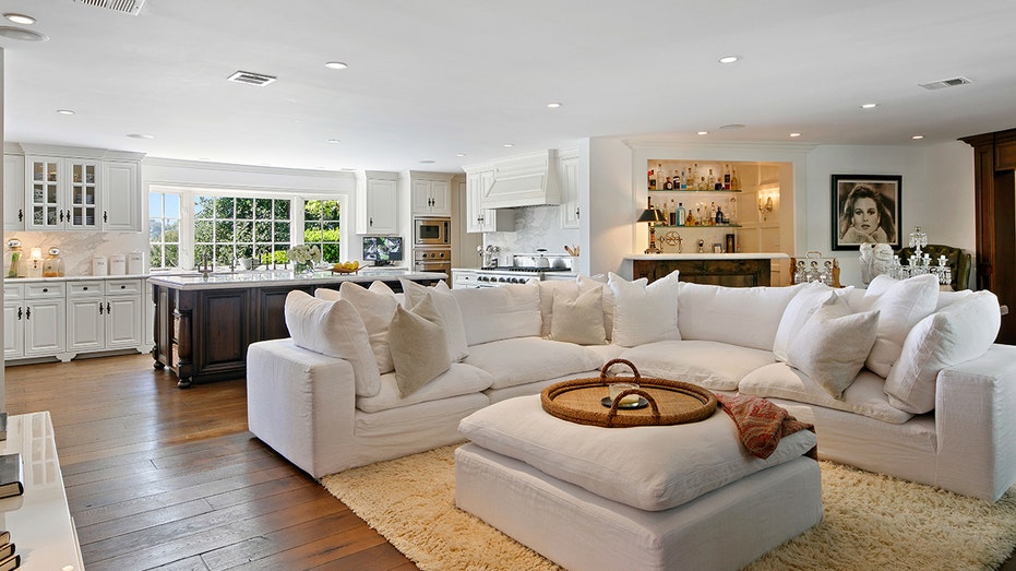 The family room features a flat-screen TV and a large white sectional sofa.