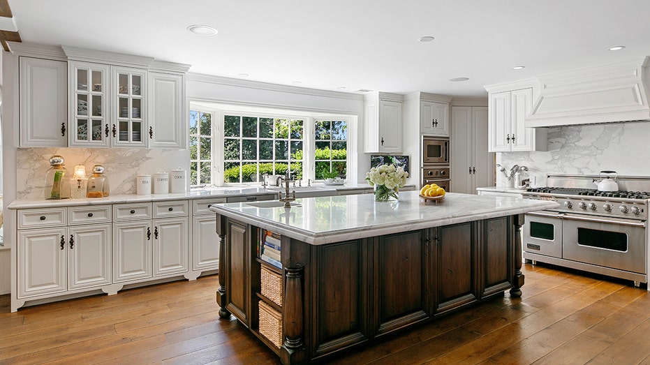 The kitchen features a large center island and three ovens to maximize efficiency. 