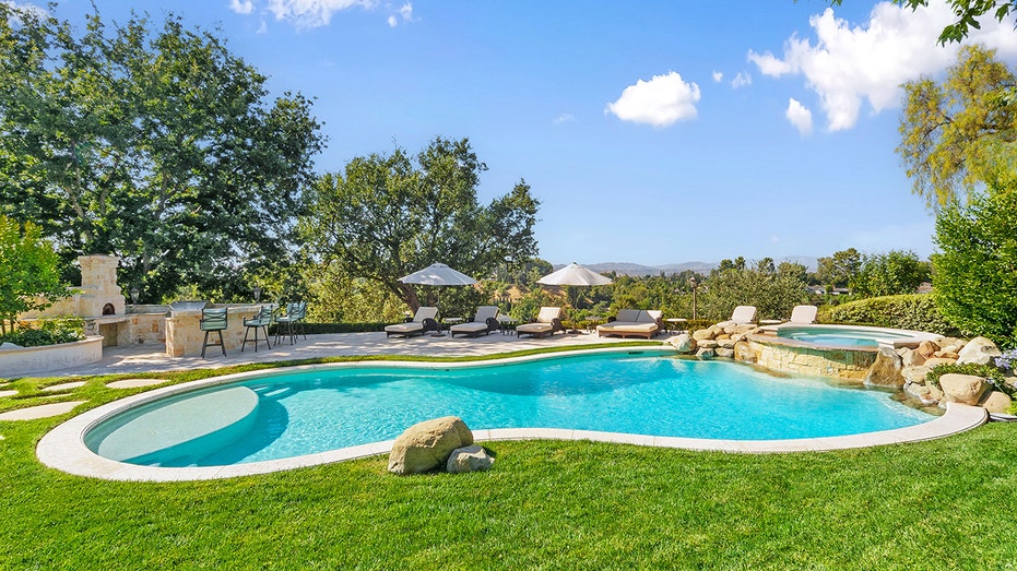 The backyard also features a swimming pool and an outdoor kitchen.