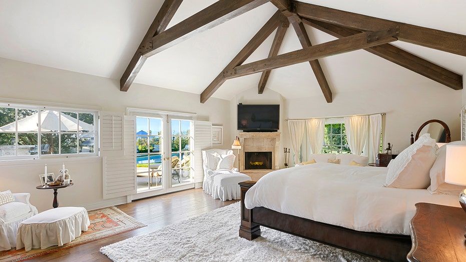 The initial bedroom has a fireplace and access to pools in the pool in the background.