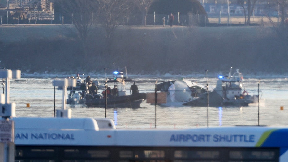 Emergency response units search the crash site of the American Airlines plane on the Potomac River after the plane crashed last night