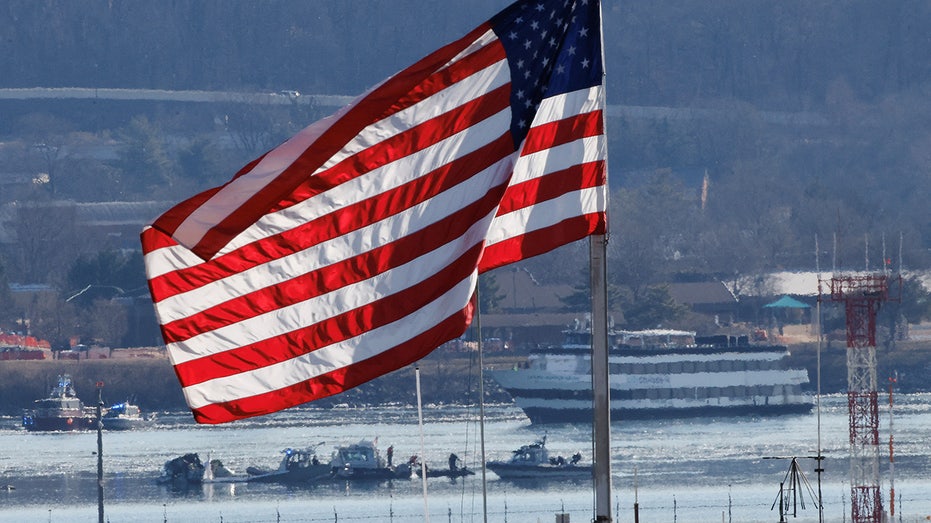 The US flag, as the news and rescue groups work after the American Eagle Flit collision 5342 and a black helicopter