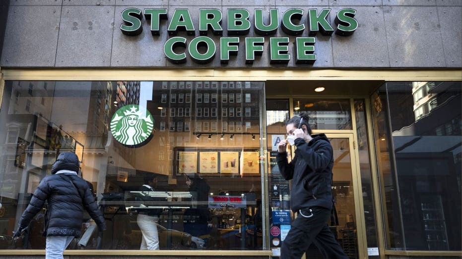 People walk past a Starbucks coffee shop 