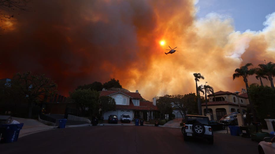 TOPSHOT - Plumes of smoke are seen as a brush fire burns in Pacific Palisades, California, January 7, 2025. A fast-moving brushfire in a Los Angeles suburb burned buildings and prompted evacuations Tuesday as and "life threatening" winds battered the region. More than 200 hectares (80 acres) burned in Pacific Palisades, an upscale area with million-dollar homes in the Santa Monica Mountains, closing a key road and blanketing the area with thick smoke. (Photo by David Swanson/AFP) (Photo by DAVID SWANSON/AFP via Getty Images)