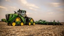 A farmer on a John Deere farm vehicle.