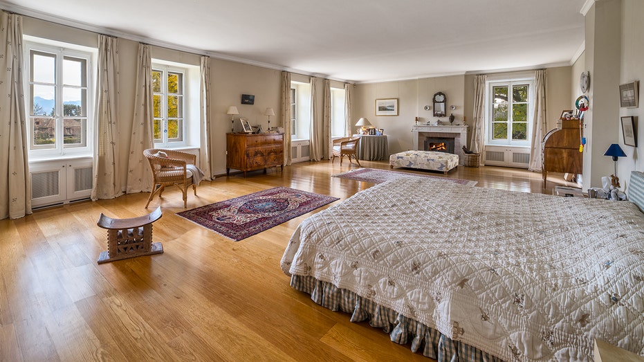 The spacious primary bedroom features a wood-burning fireplace and multiple windows.