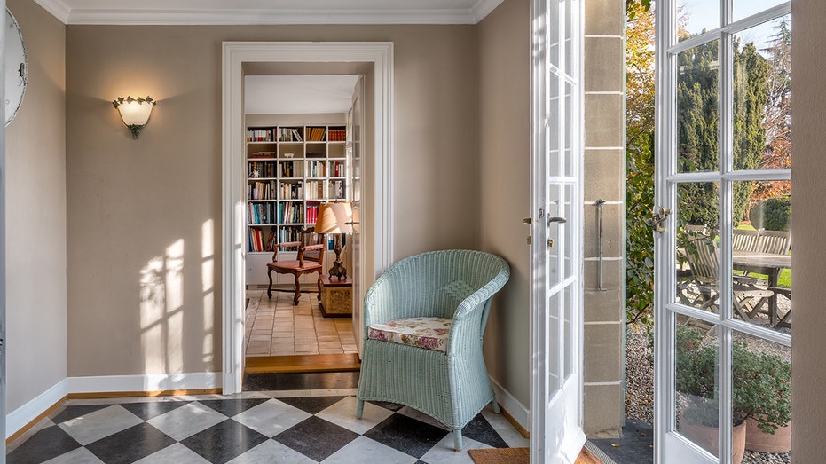 A small seating room with a black and white floor and a door outside.