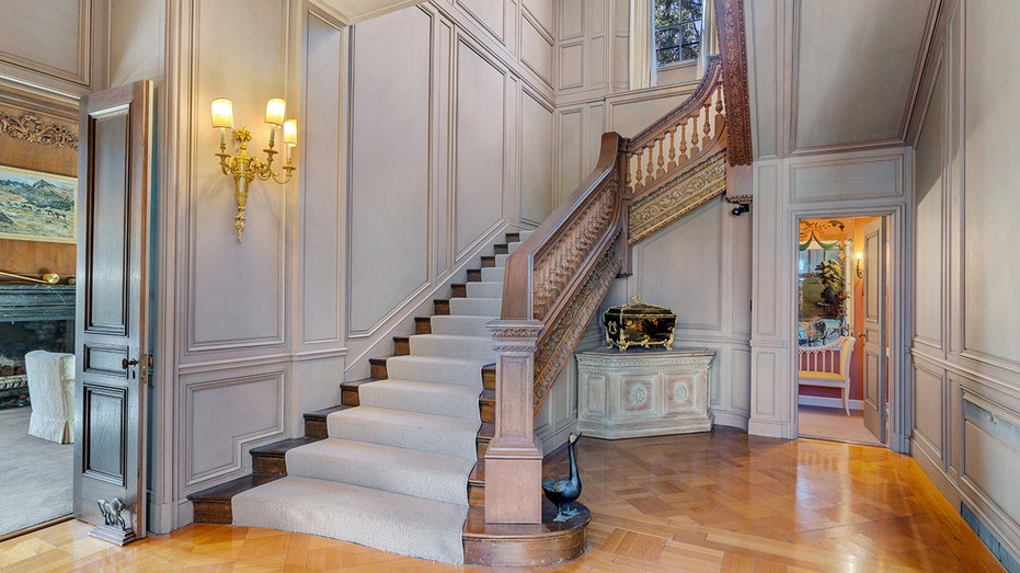 The grand staircase features a wooden banister built with wood sourced from Europe by William Randolph Hearst.