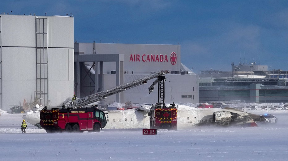 First responders work at the Delta Air Lines plane crash