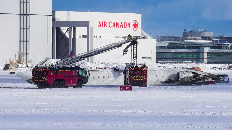 First responders work at the Delta Air Lines plane crash