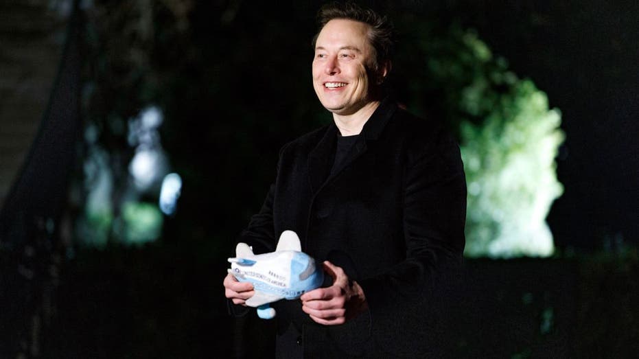 Elon Musk holding an Air Force One toy