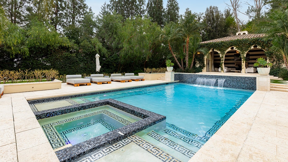 The backyard includes a large swimming pool with a waterfall.