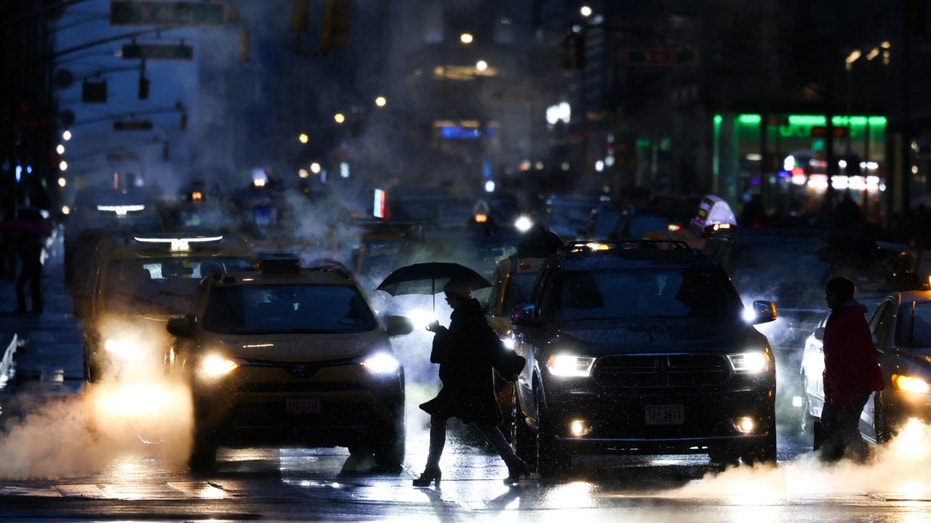 People walk along the nap avenue in Midtown Manhattan as snows falls in New York City on February 15th.