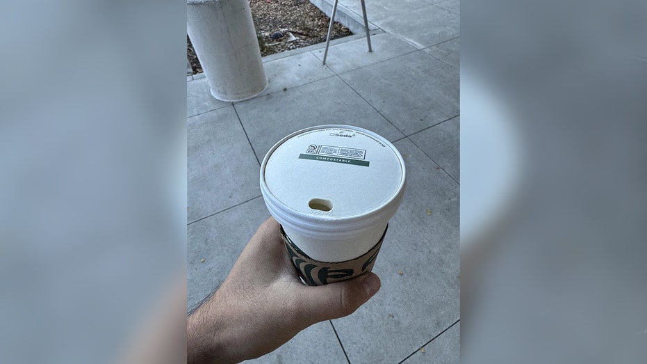 hand holding a Starbucks compostable cup