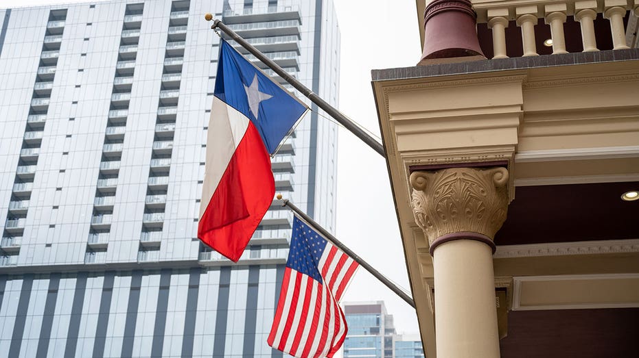 Bendera Texas dan bendera Amerika dikibarkan bersama di sebuah gedung di Austin, Texas, 11 Maret 2023. (Foto oleh Smith Collection/Gado/Getty Images)