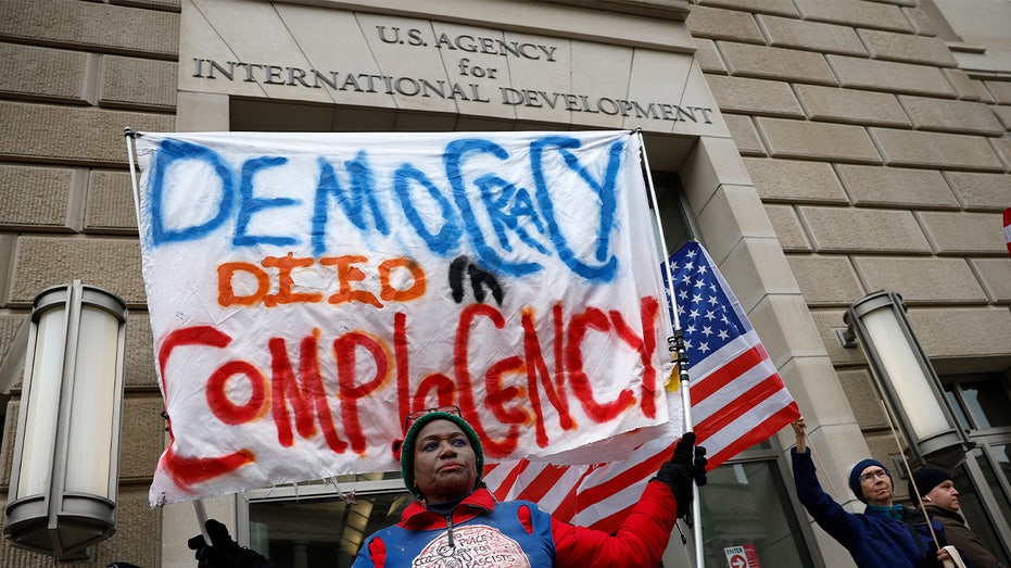 Protestors stand outside USAID