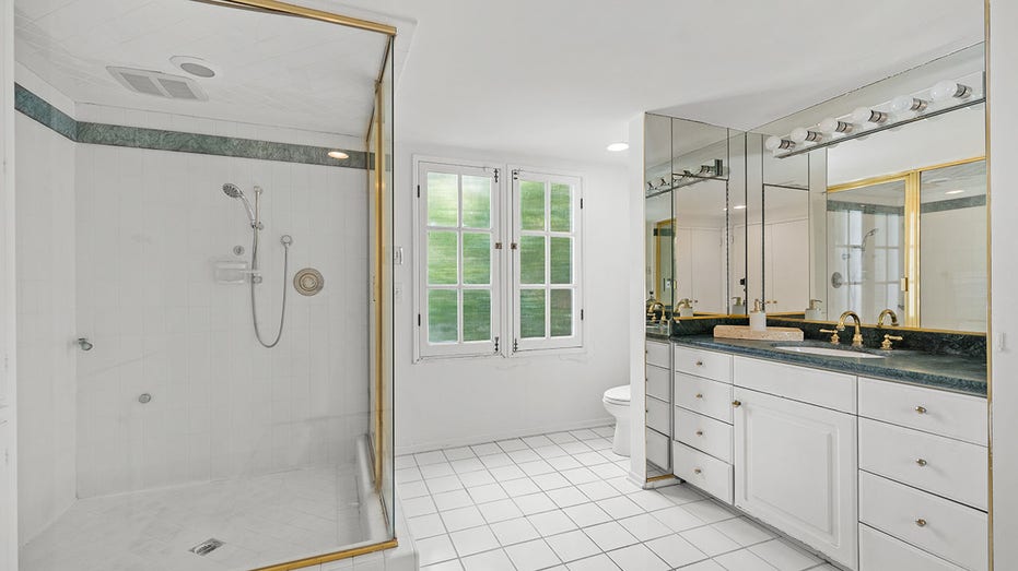 The ensuite bedroom features a standing shower and a large vanity.