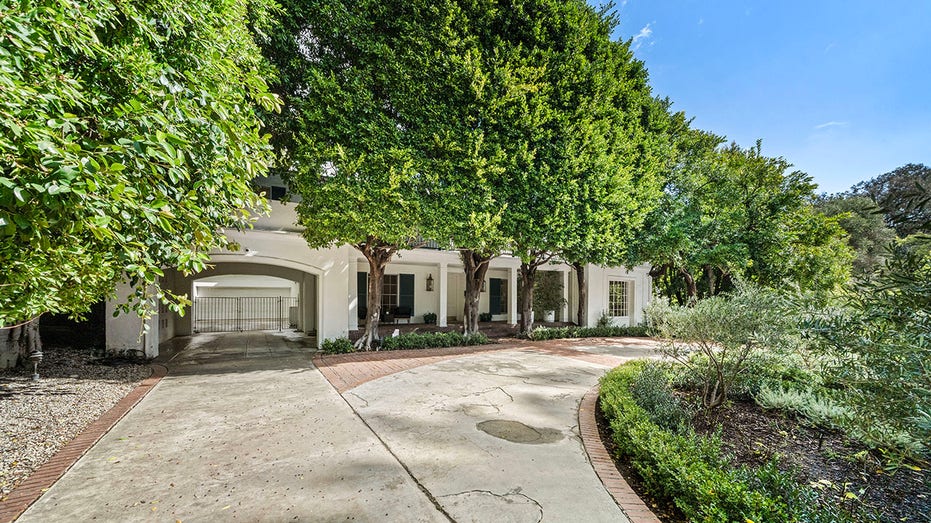 A gated circular driveway leads to the home's front door.