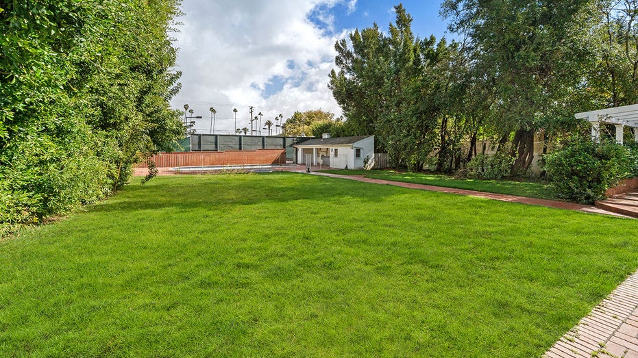 The backyard also boasts a large grass field, perfect for entertaining.