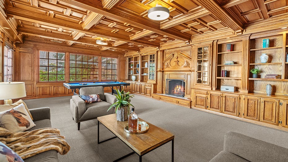 The home's great room features coffered ceilings and head-to-toe wood-paneling.