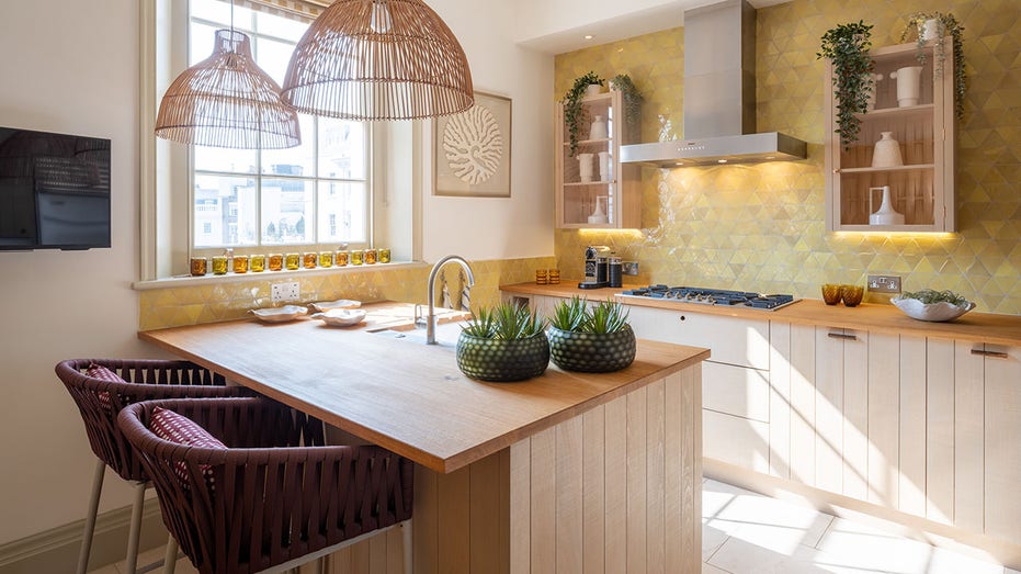 The kitchen boasts oak countertops, paneled cabinets, yellow-tiled walls and a breakfast bar.