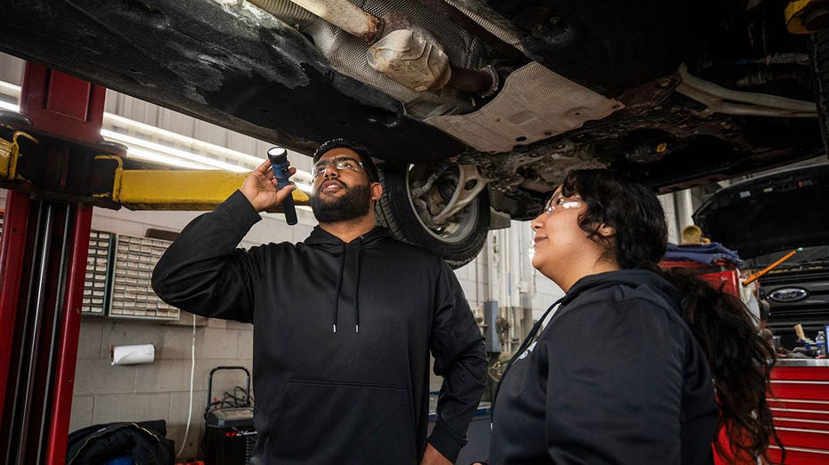 Auto tech students looking at the underside of a vehicle