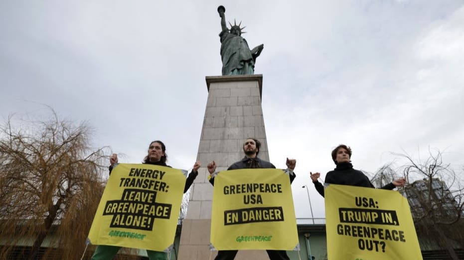 France's Greenpeace activists perform an action to support Greenpeace USA, next to Statue of Liberty at Pont de Grenelle in Paris on February 20, 2025. Energy Transfer, the Big Oil company behind the Dakota Access Pipeline, is suing Greenpeace USA for $300 million. (Photo by Thibaud MORITZ / AFP) (Photo by THIBAUD MORITZ/AFP via Getty Images)
