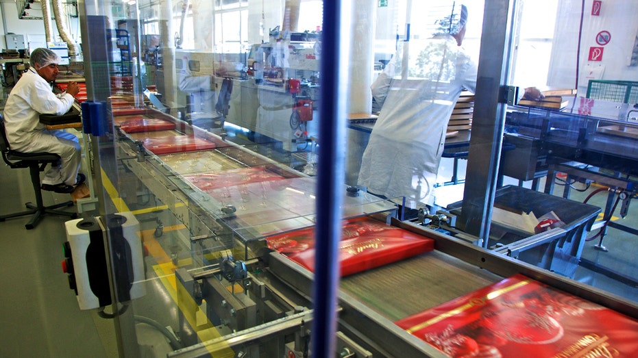 employee monitors boxes of Lindt chocolate packaged at a factory