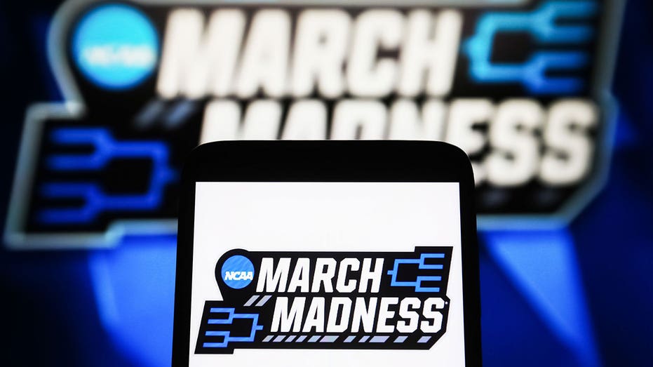 Ukraina - 2024/04/09: Dalam ilustrasi foto ini, logo March Madness (NCAA Divisi I Men's Basketball) terlihat di smartphone dan layar PC. (Ilustrasi foto oleh gambar pavlo gonchar/sopa/lightrocket melalui gambar getty)