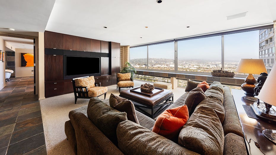 The family room boasts a large flat screen TV and floor-to-ceiling windows.