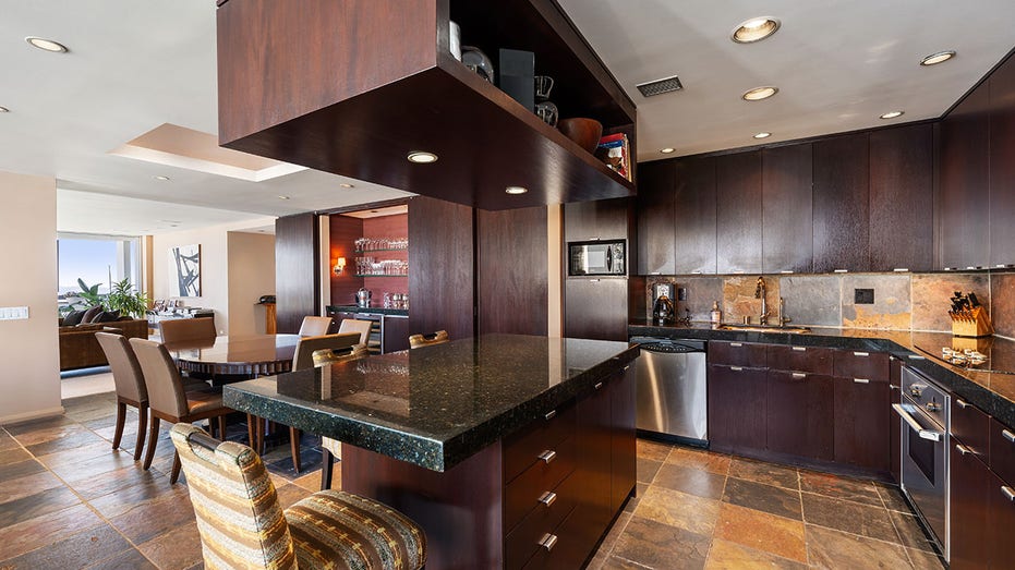 The kitchen features stainless steel appliances and a breakfast bar.