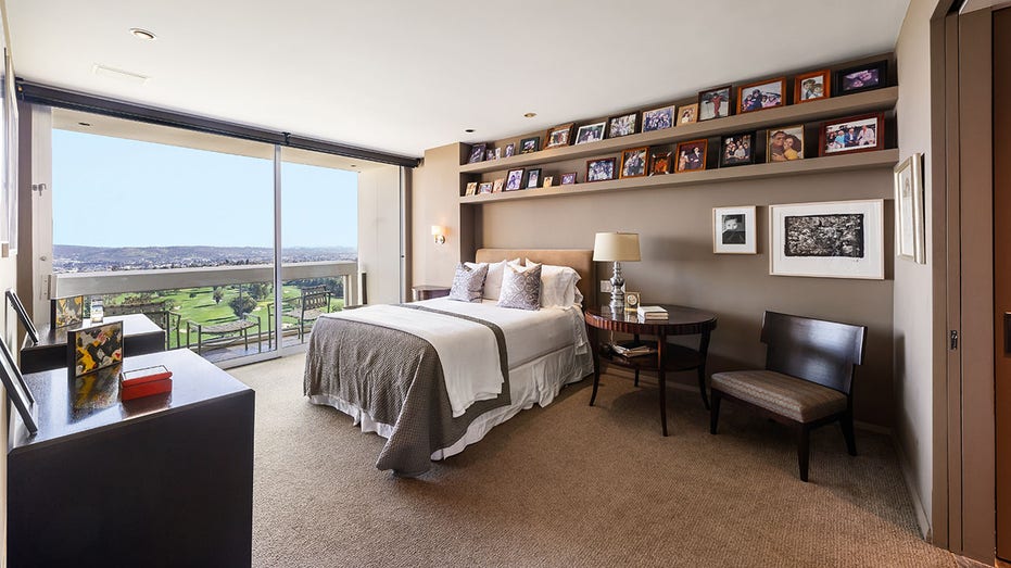 The primary bedroom features its own private outdoor seating area and shelving above the bed.