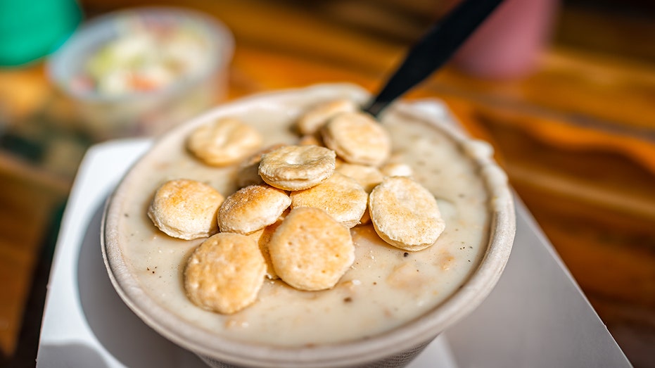 Clam chowder chunky creamy seafood soup mangkuk di restoran gubuk dengan disajikan sebagai hidangan hidangan New England tradisional dengan kerupuk tiram, coleslaw