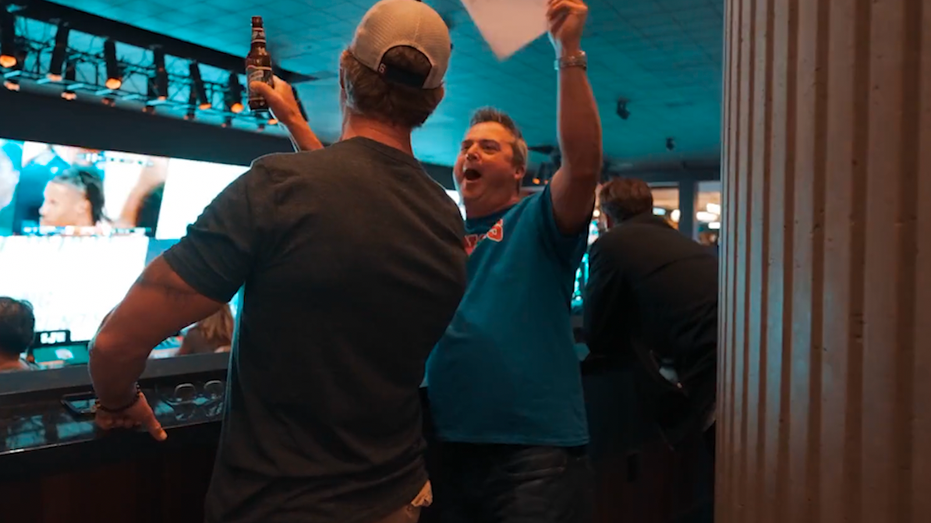 Men cheering while watching the basketball tournament.