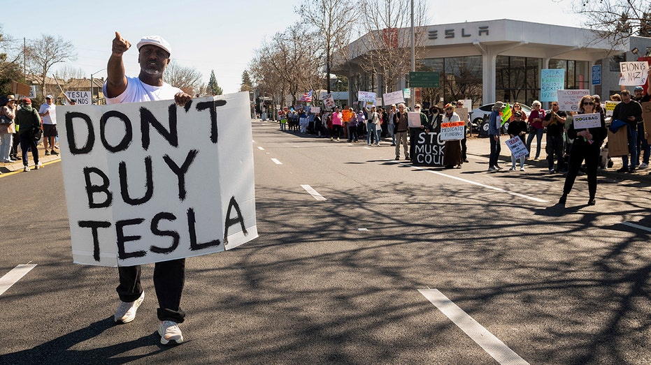 Orang -orang memprotes di luar dealer Tesla di California